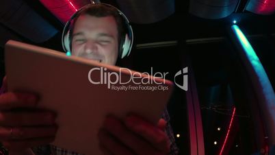 Man enjoying music with pad at sky deck at night