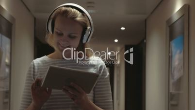 Woman with pad enjoying music in headphones