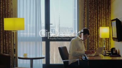 Young businessman busy with work in hotel room
