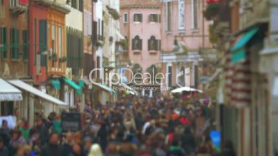 Crowd of people walking along Venetian street