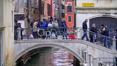 People crossing the small bridge in Venice