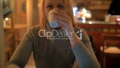 Woman using pad and having tea in cafe