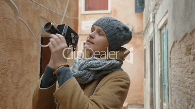 Female tourist using retro video camera outdoor