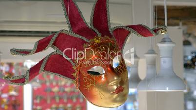 Red Venetian mask hanging in the store