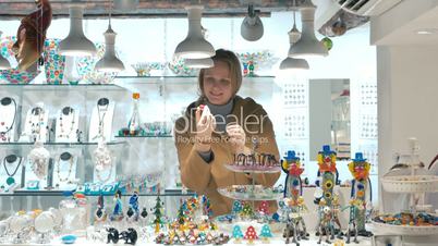 Woman tourist choosing souvenirs in Venetian shop