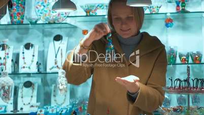 Woman Choosing a Gift in Murano Glass Shop in Venice