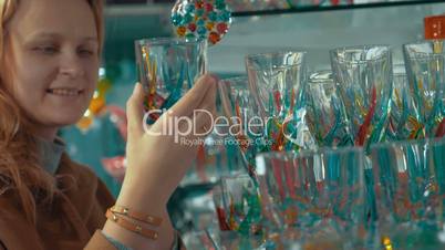 Young woman looking at Venetian glass in the store