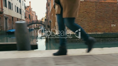 Woman in haste moving along Venetian canal