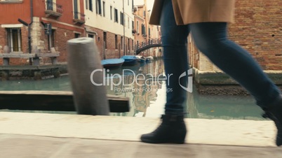 Woman in Venice walking along the canal