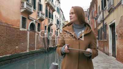 Woman wandering in Venice with pad