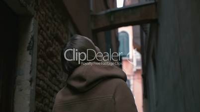 Woman in alleyway looking around