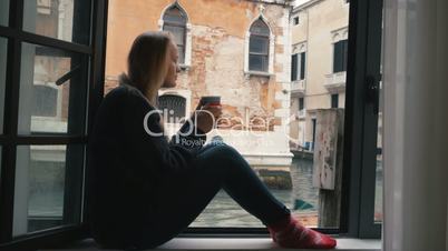 Woman drinking coffee and looking at Venice view