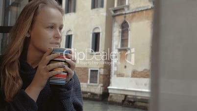 Woman enjoying hot tea and outside view