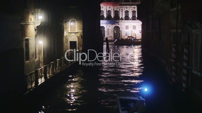 Boat sailing along the canal in Venice at night