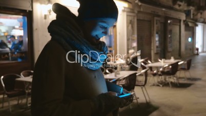 Woman with cell phone outdoor at night