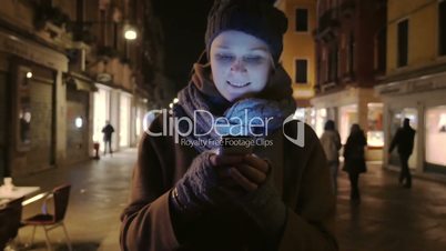 Woman walking at night and chatting on cell phone