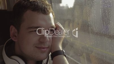 Man traveling by train and enjoying outside view