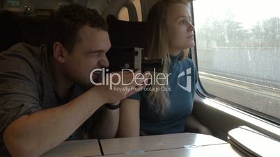 Young couple with retro video camera in train