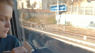 Woman taking notes or drawing in train