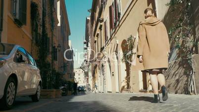 Woman walking along old narrow street