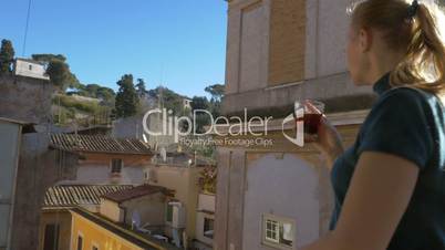Woman with cup of tea enjoying view from the balcony