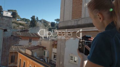 Woman with retro camera on the balcony