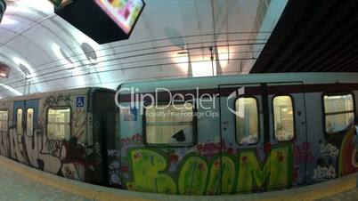 Undeground train with graffiti leaving station