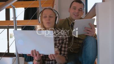 Young couple in heaphones at home enjoying music