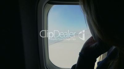 Woman looking out the window in airplane