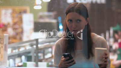 Woman with Smartphone in Coffee Shop