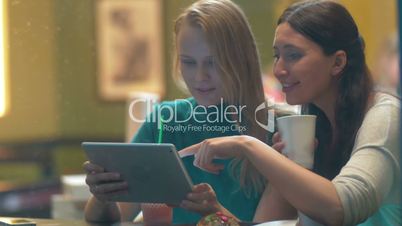 Women in Cafe Laughing at Something in Tablet PC