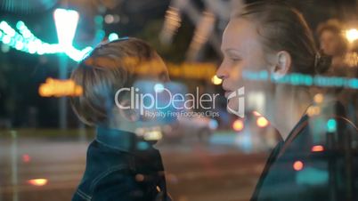 Happy mother and child talking in night city