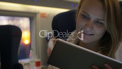 Smiling woman with touch pad in express train