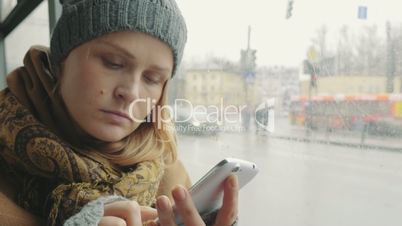 Woman texting on cell phone during bus ride in city