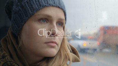 Frustrated and sad woman traveling by bus on rainy day