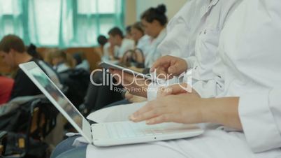 Medical students using laptop and pad on the lecture