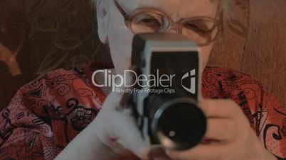 Senior woman filming with retro video camera