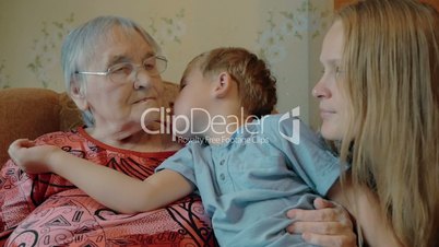 Little boy expressing love to mother and grandmother with kisses