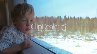 Boy Looking Out the Window of Moving Train