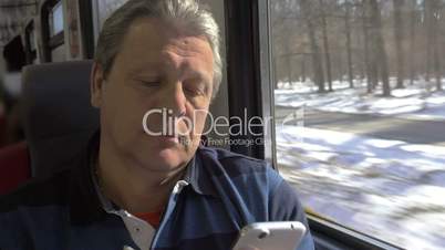 Mature Man Using Smartphone while Train Trip