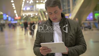 Man using digital tablet in airport hall