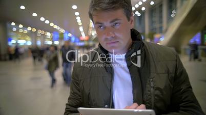 Man with Tablet PC in Airport or Railway Terminal