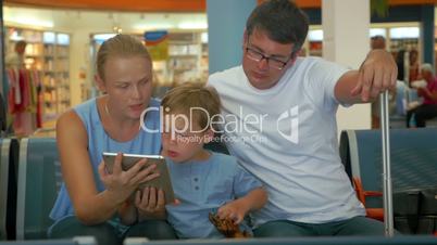 Family Waiting for Departure with Tablet PC