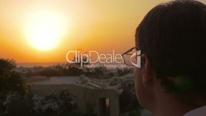 Man putting on spectacles to enjoy the sunset