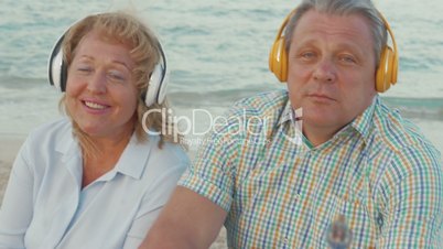 Senior couple enjoying music on the beach