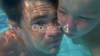 Father and son diving together in the pool