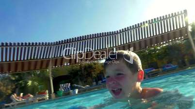 Child enjoying swimming in outdoor pool