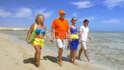 Young and senior people walking at the seaside together