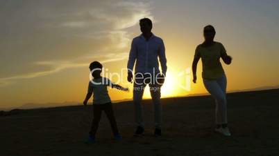Parents and Son Dancing at Sunset