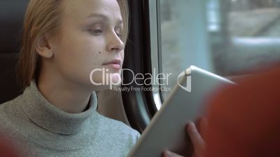 Smiling Woman with Tablet in Train